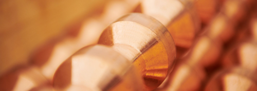 Close-up of copper metal arranged in rows with a blurred background