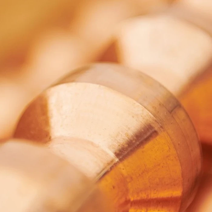 Close-up of a metallic cylindrical object with a reflective surface and warm lighting.